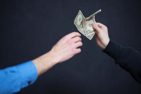 Concept - corruption. Giving a bribe. Money in hand