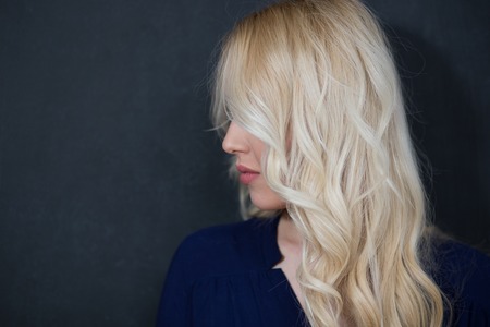 Blond woman in shirt against chalkboard, copyspaceの写真素材