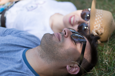 Love romance relationship dating relax concept. Affectionate couple on grass. Young enamoured girl and boy show affection in park.の写真素材