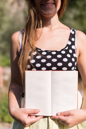 woman holding open book in natureの写真素材