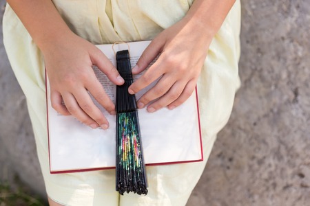 Close-up of female hands holding open book. Reading concept backgroundの写真素材