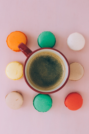 A cup of morning americano coffee with colorfull french macarons on a  pink backgroundの写真素材