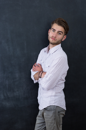 Portrait of young happy smiling teacher man standing near chalkboard backgroundの写真素材