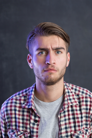 Portrait of a cheerful young man in checkered shirtの写真素材