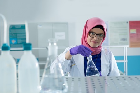 muslim lab worker with hijab or researcher doing an analysis in labaratoryの写真素材