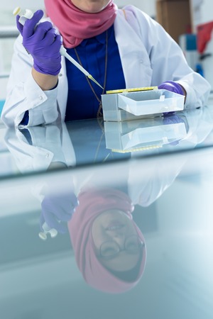 muslim lab worker with hijab or researcher doing an analysis in labaratoryの写真素材