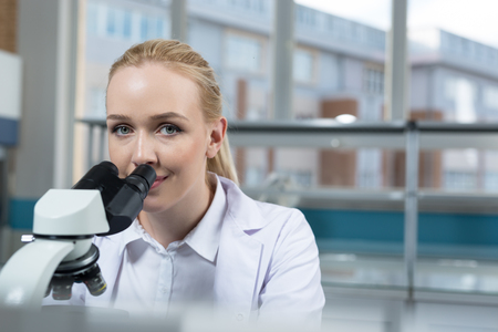 Young scientist in white uniform working in laboratoryの写真素材