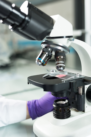 Scientist hands with microscope close-up shot in the laboratoryの写真素材