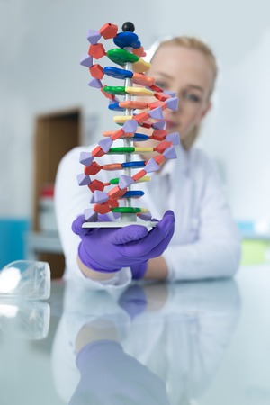Woman scientist holding DNA moleculeの写真素材