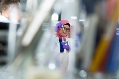 muslim lab worker with hijab or researcher doing an analysis in labaratoryの写真素材