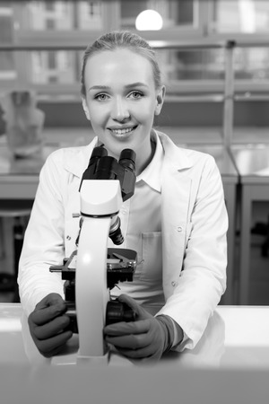 Female researcher using her microscope in a laboratoryの写真素材