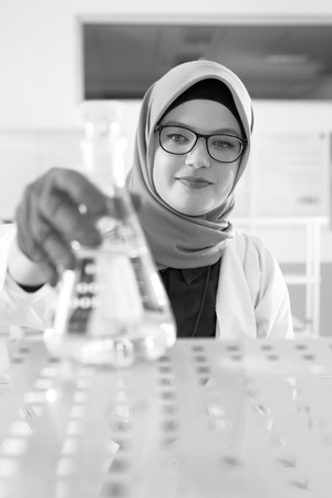 muslim lab worker with hijab or researcher doing an analysis in labaratoryの写真素材
