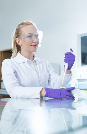 Young scientist in white uniform working in laboratoryの写真素材