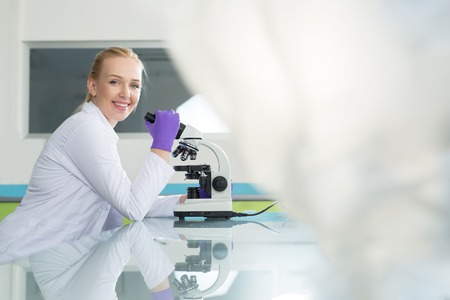 Doctor woman with microscope in laboratory. Scientific research.の写真素材