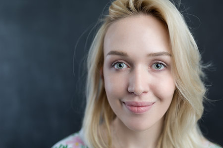 Caucasian woman standing in front of a dark chalkboard.の写真素材