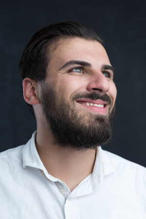 Portrait of a  young bearded man against black chalkboardの写真素材