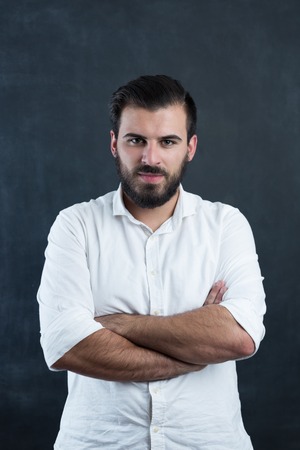 Portrait of a  young bearded man against black chalkboardの写真素材