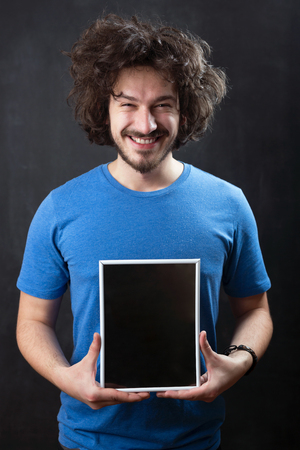 man holding blank black board with white frameの写真素材