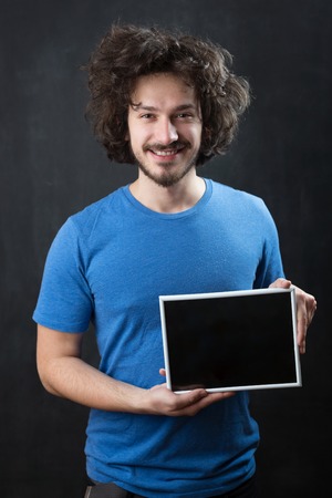 man holding blank black board with white frameの写真素材