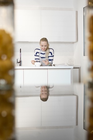 Young woman having a bowl of cereal in kitchenの写真素材