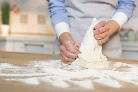 Making dough by female hands at kitchen