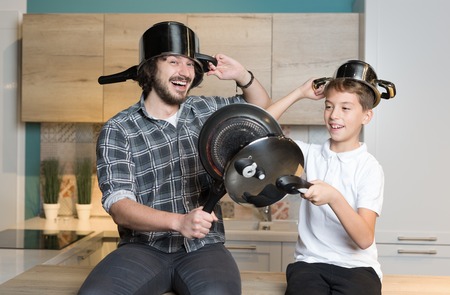 father and kid having great time in kitchen. Father and son having fun with kitchen pots. Concept of togethernes and familyの写真素材