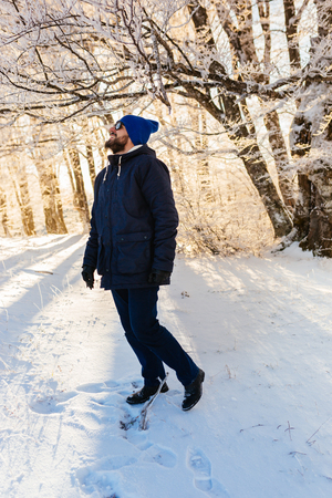 Handsome man in winter cloth  in park on sunny winter dayの写真素材