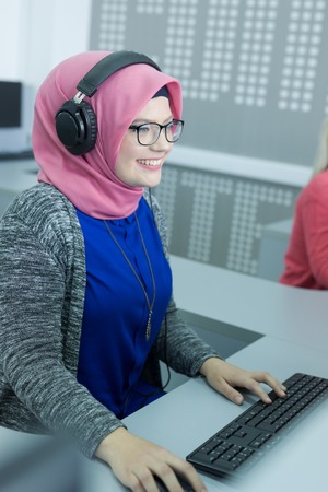 attractive modern Arabian businesswoman in traditional clothing working in officeの写真素材