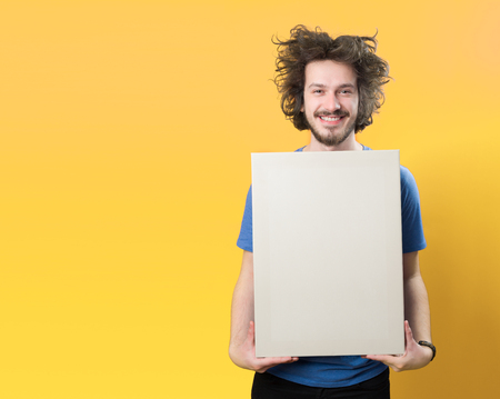Bearded man with mustache and funny hair holding blank white board on orange  backgroundの写真素材