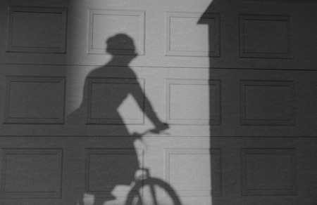 Shadow of a woman riding a bike on a textured wall. Two tonal imageの写真素材
