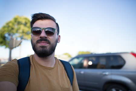 Handsome black bearded man as a tourist exploring the city. Portrait of a european handsome man.の写真素材