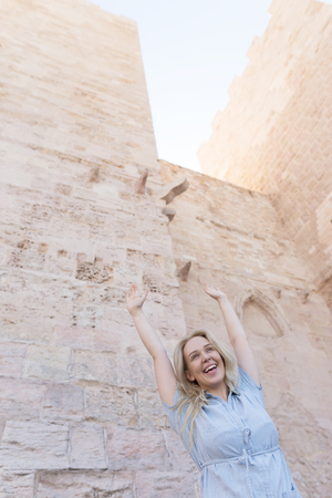 Photo of a beautiful blonde woman against the rustic church wall in France in Marseilleの写真素材