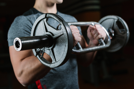 Closeup of a person holding an weights, with head cropped. Bodybuilding concept.の写真素材