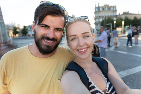 Capturing bright moments. Joyful young loving couple making selfie on camera while standing outdoorsの写真素材