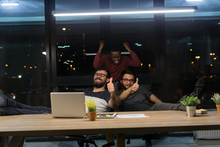Businessmen consulting at their office in night time working overtime.の写真素材