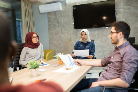 Business meeting in a modern office, multiracional colleagues collaborating together.の写真素材