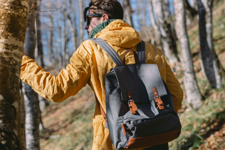 Young man standing in the forest and exploring, freedom and nature conceptの写真素材