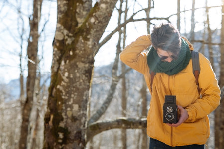 retro stylized photo of young man photographer with vintage camera