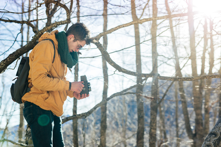 retro stylized photo of young man photographer with vintage cameraの写真素材
