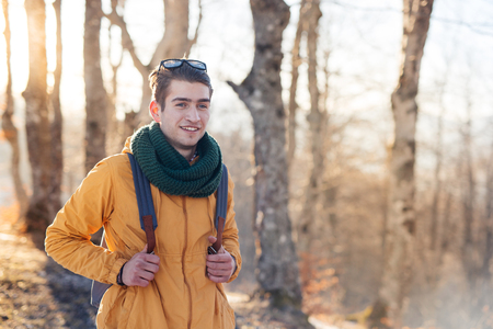 Young man standing in the forest and exploring, freedom and nature conceptの写真素材