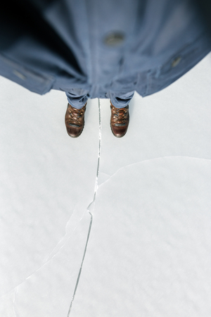 frozen lake with ice crack and boots の写真素材