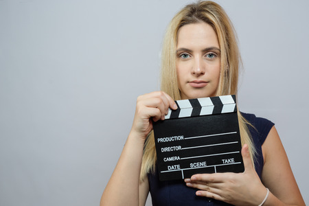 Young woman in action, holding clapperboard. Cinema conceptの写真素材