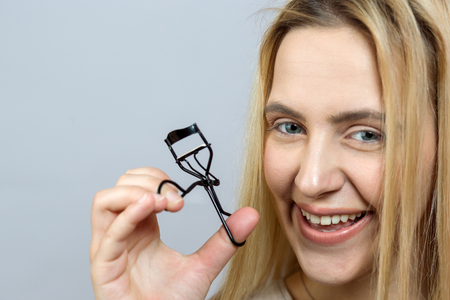 Woman using curler tool for eyelashesの写真素材
