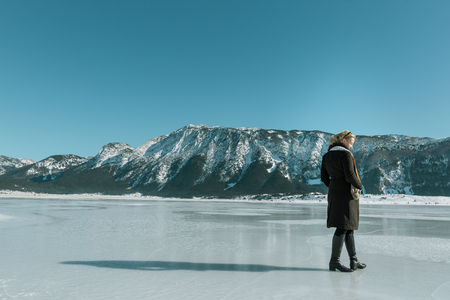 woman enjoying beautiful day on frozen lakeの写真素材