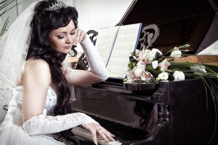 The bride looks thoughtfully at the pianoの写真素材
