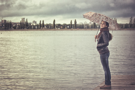 lonely girl with an umbrella in the city reservoirの写真素材