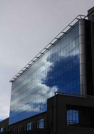 Dark clouds reflected in a glass facade.