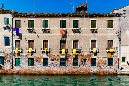 Traditional Venetian building by water with windows and shutters in Venice, Italyのeditorial素材