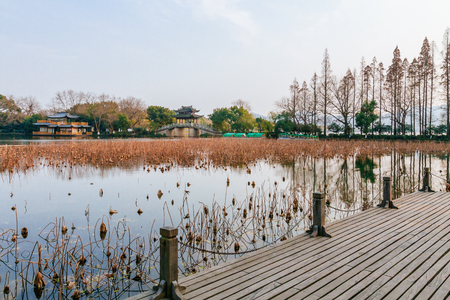 Chinese pavilions and stone bridge over water near West Lake in Hangzhou, Chinaの写真素材