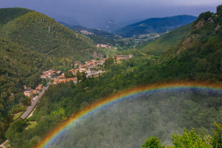View of rainbow over town and landscape near Marmore Falls, Umbria, Italyの写真素材